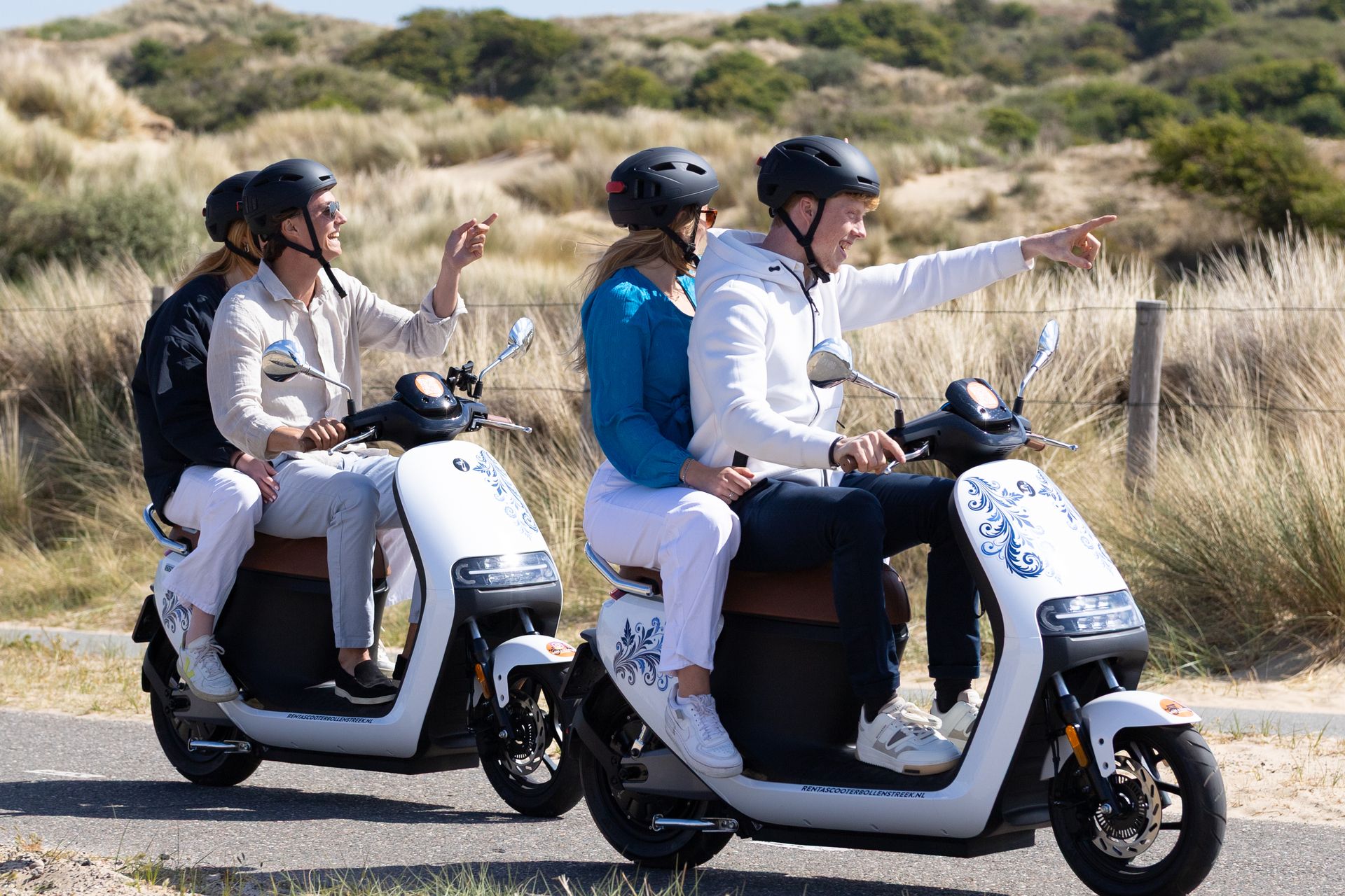 Twee stellen rijden met elektrische scooters door de duinen van de Bollenstreek